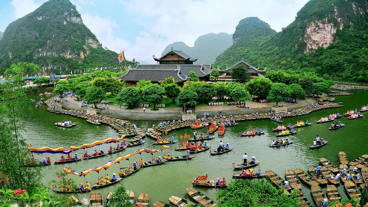 Vibrant boat festival at Trang An with colorful festivities and scenic nature.