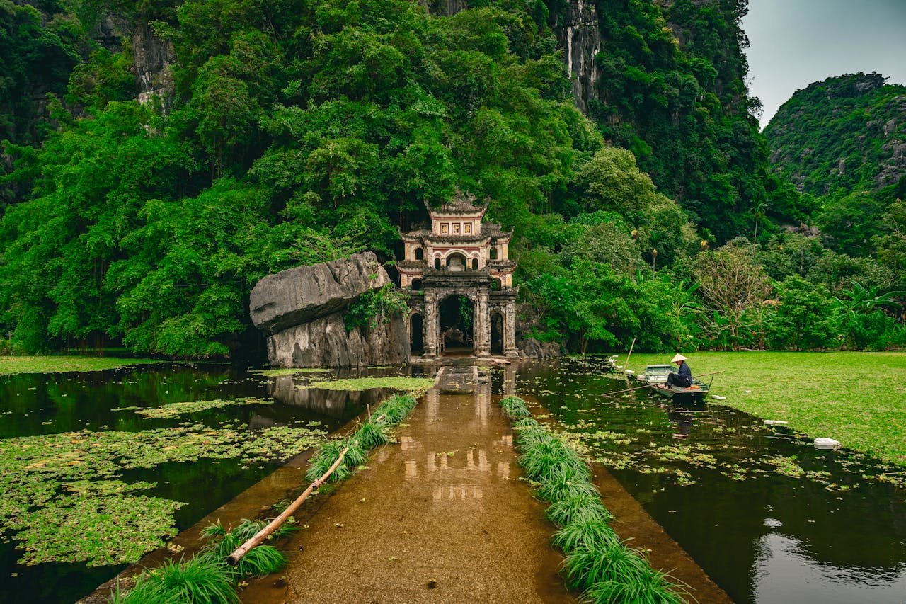 Serene landscape with a traditional temple surrounded by lush greenery and a tranquil pond in Bac Giang, Vietnam.